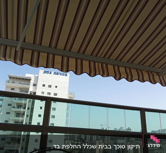 סוכך פסים בצבעים חום ולבן על מרפסת